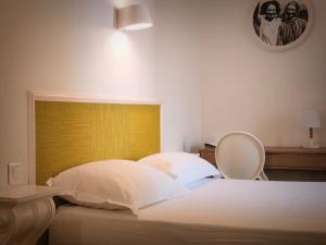 巴斯蒂亚Sud Hôtel Restaurant的一间卧室配有一张白色床和黄色床头板
