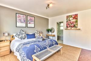 开普敦Trendy 1 bedroom flat in the heart of Green Point的一间卧室配有一张带蓝色和白色床单的床。