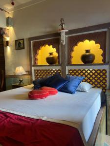 焦特布尔Raj Mandir Boutique Home Stay的一张带两个红色和蓝色枕头的床