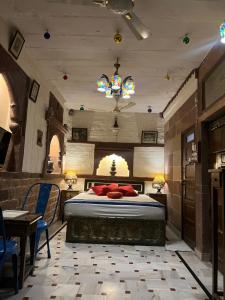 焦特布尔Raj Mandir Boutique Home Stay的卧室配有一张床和一张桌子及椅子
