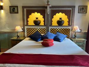 焦特布尔Raj Mandir Boutique Home Stay的一间卧室配有蓝色和红色枕头的床
