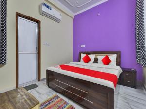 斋浦尔OYO Flagship Hotel Hastinapur Residency的一间卧室设有一张紫色墙壁的大床