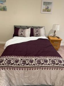 Saint IvesGuest suite Annex private room的一间卧室配有一张带紫色和白色棉被的床