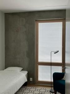 于韦斯屈莱Tikka Apartments的一间卧室设有一张床、一个窗口和一把椅子