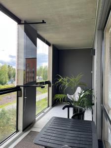于韦斯屈莱Tikka Apartments的阳台配有桌椅和大窗户。