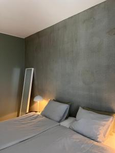 于韦斯屈莱Tikka Apartments的卧室内的一张带两个白色枕头的床