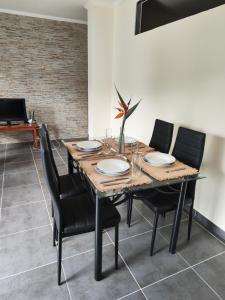 Ribeira da JanelaQuinta' Home的用餐室配有木桌和黑椅子