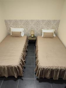 Ribeira da JanelaQuinta' Home的两张睡床彼此相邻,位于一个房间里