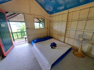 象岛Neeno Hut的小房间设有一张床和一个风扇