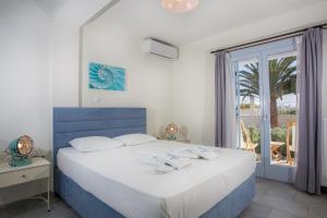 斯基罗斯岛Amphitrite Apartments Skyros的卧室配有蓝色和白色的床和窗户。