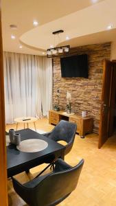 代温Eda Aparts的客厅配有桌椅和电视。