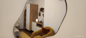 拉布Rooms and Apartments Riviera的镜子反射着一个房间,房间配有椅子和楼梯