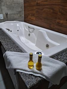 皮拉尼亚斯Hotel Reserva do Xingó的两瓶啤酒坐在浴缸旁的毛巾上