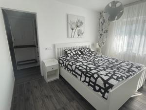 BuzăuVulcan Apartment的一间卧室配有一张带黑白色棉被的床