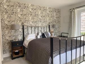 韦姆Abbey Green Farm的一间卧室配有一张床和花卉壁纸