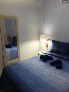 皮帕Casa Completa Prox Centro de Pipa的一间卧室配有一张蓝色的床和大镜子