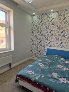 乌兰巴托Deegii's house的一间卧室配有一张带花卉图案墙壁的床
