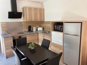 维琪奥港朵儿斯维塔巴隆巴热亚公寓的厨房配有黑桌和冰箱。