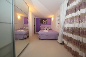 罗马迪埃斯梅度假屋的一间设有两张床和紫色墙壁的客房