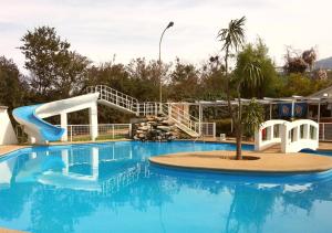 奥尔穆埃Hostería y Spa Llano Real的一个带蓝色水滑梯的大型游泳池
