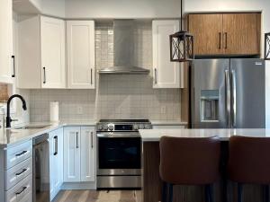 金斯顿Luxury Detached House Kingston的厨房配有白色橱柜和不锈钢用具
