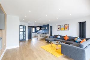 布莱顿霍夫Stylish & modern 4-bedroom home with sea views的客厅配有沙发和桌子