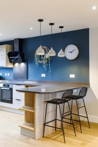 布莱顿霍夫Stylish & modern 4-bedroom home with sea views的厨房配有带2把椅子和1个时钟的柜台