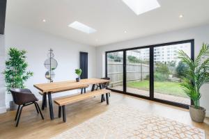布莱顿霍夫Stylish & modern 4-bedroom home with sea views的一间带桌椅和大窗户的用餐室
