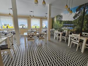 BondaryDolcevita Podlasie的餐厅设有白色的桌椅和窗户。