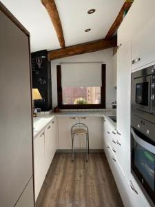OlopteIdílico refugio de montaña ideal escapadas的厨房配有白色橱柜和椅子