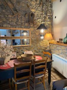 OlopteIdílico refugio de montaña ideal escapadas的一间设有桌子和石墙的用餐室