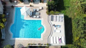 康托卡利Casa T with amazing views in Corfu的享有带椅子和遮阳伞的游泳池的顶部景致
