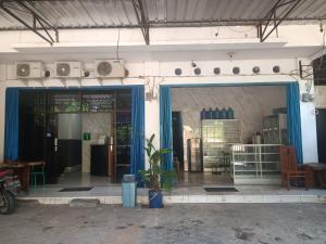 查亚普拉OYO 93117 Penginapan Tiga Dara的一间有蓝色门和盆栽的商店前