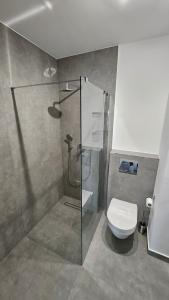 波兹南APARTAMENT BUŁGARSKA 60m2-3 POKOJE-PIĘKNY WIDOK-13 PIĘTRO 24H CHECK IN的一间带玻璃淋浴和卫生间的浴室