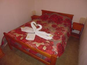 GualeguaychúComplejo Sol y Luna的一张带两个天鹅的床铺,被毛巾包住