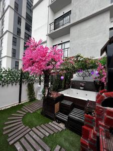 瓜达拉哈拉Departamento Inteligente con Jacuzzi Privado en Zapopan的花园拥有粉红色的花卉树木和浴缸