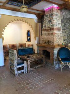 舍夫沙万alberegue Rustica的客厅设有石制壁炉、桌子和椅子