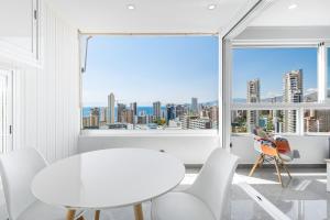 贝尼多姆Gemelos 22-3-21D Apartment Deluxe Levante Beach的享有城市美景的白色用餐室