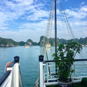 河内Halong Bay Full Day Cruise Kayaking, Swimming, Hiking:ALL INCLUDE的船上的船,背靠群山
