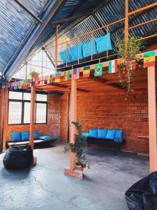 拉巴斯Lobo Hostel La Paz的一间设有蓝色沙发和砖墙的房间