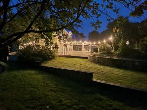 CarrickmoreGap Retreat的夜晚在院子里有灯的白色房子