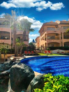 圣米格尔德阿沃纳Casa Palmu apartment - A peaceful and relaxing oasis in Golf del Sur, Tenerife的大楼前的游泳池