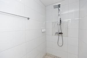 Six Mile BottomThe Mayfair的白色的浴室设有淋浴和淋浴头