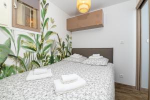 锡富尔勒普拉日Le Verd'ô - Piscine - Plage - Parking - Wifi - MyBestLoc的一间卧室配有两张床和白色毛巾。