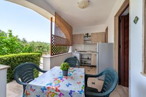 卡斯泰诺福奇伦托Residence Martino - Casa Vacanze的厨房配有桌椅和冰箱。