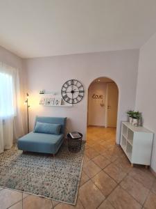 菲乌米奇诺Il Nido Casa indipendente a Fiumicino Self check in的客厅配有蓝色的沙发和墙上的时钟