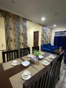 斯利那加Khwaab Gah by The Khayabaan-HomeStay 3 BHK, 2 BHK & 1 BHK Apartments in City Centre的一间带桌子和蓝色沙发的用餐室