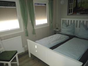 VisselhövedeTiny Bungalow Visselhövede的卧室配有白色的床和2扇窗户。