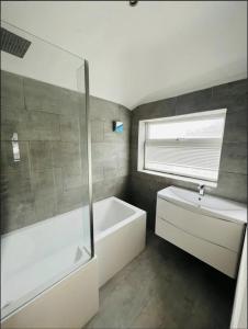 牛津Mark Road Villa的浴室配有白色浴缸和水槽