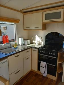 PortknockieMelody Brooks Caravan Park Caravan number 22的小厨房配有炉灶和水槽